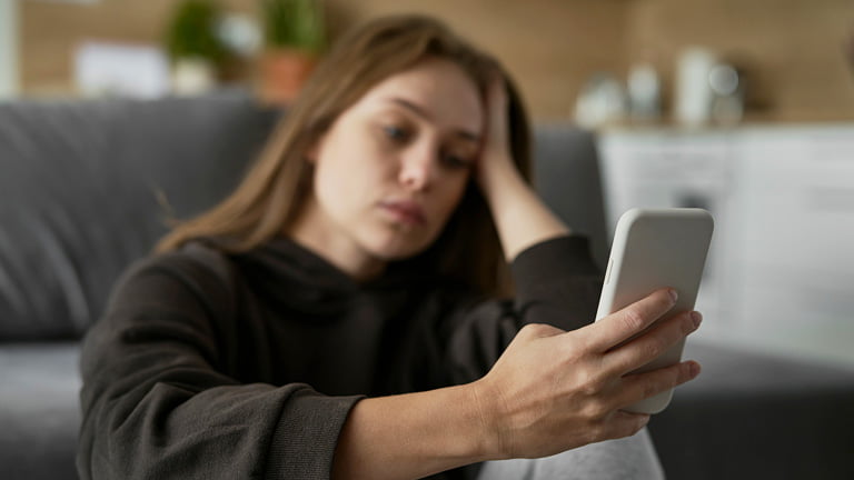 A woman holding smartphone is stressed out because of damaged SIM card