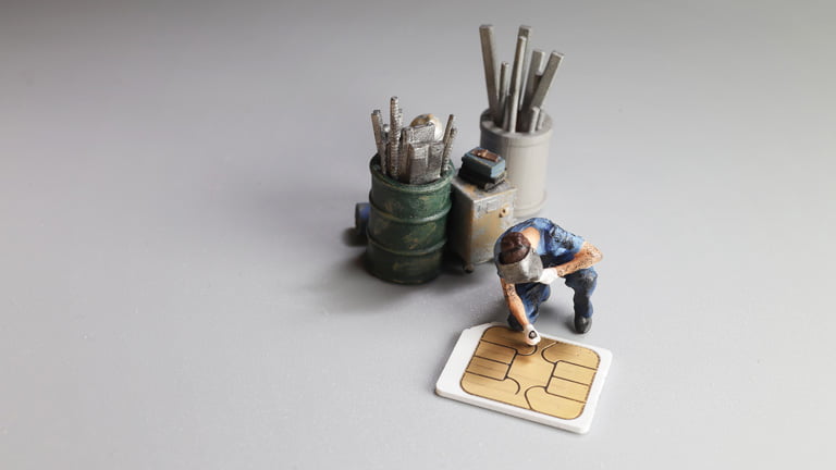 A miniature man is checking the damaged SIM card