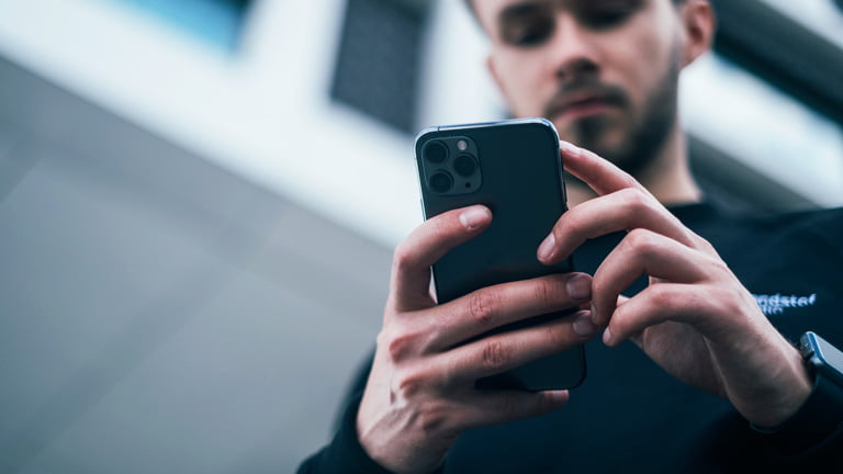 A man holding iPhone to figure out how to use data without SIM card